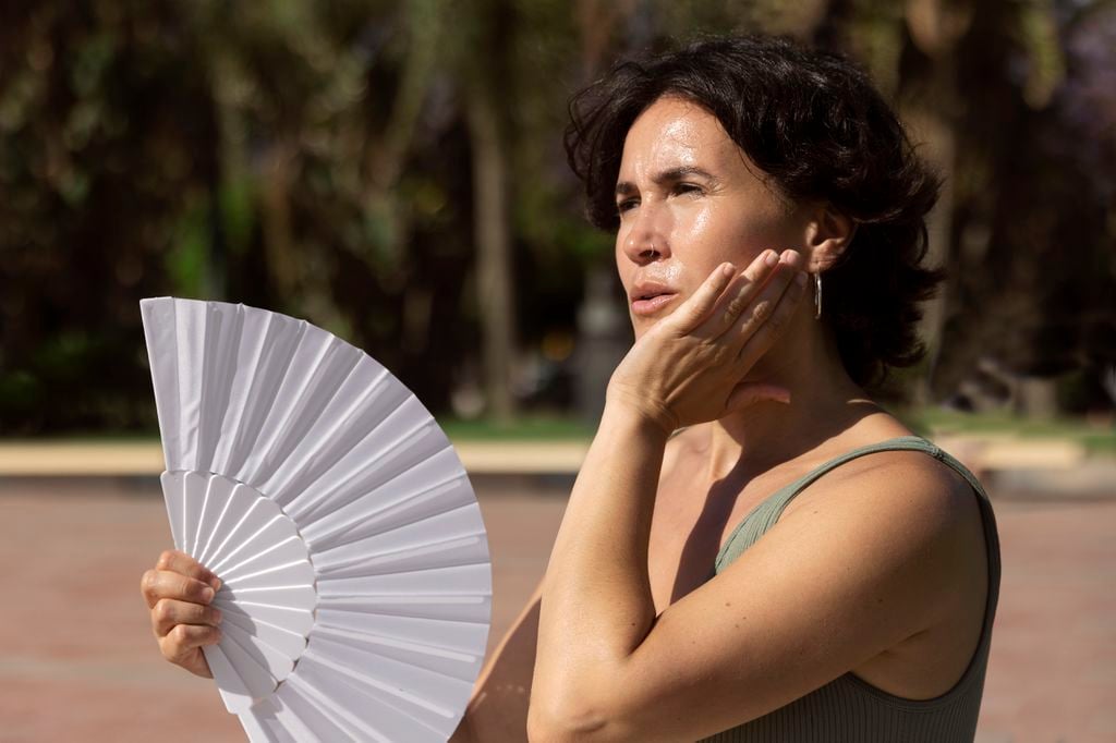 Mulher passando mal de calor em dia de sol