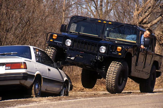 Hummer H1 passando por cima de um carro