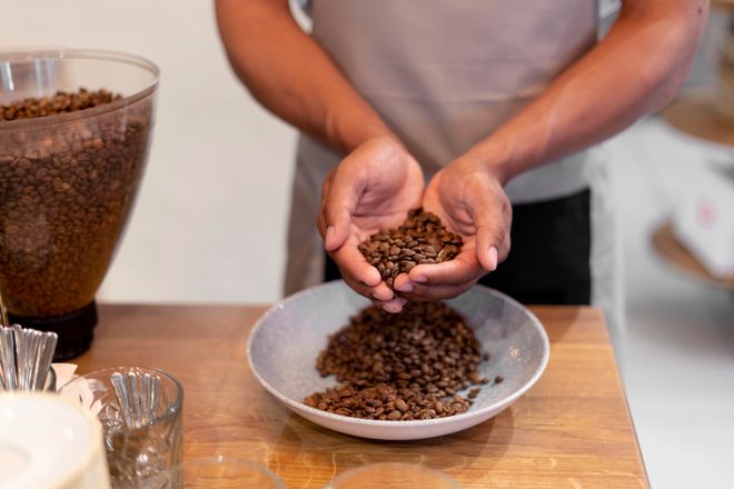 Homem segurando grãos de café