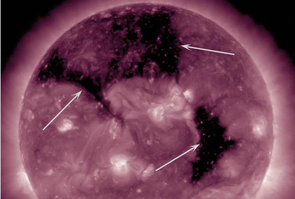 Imagem registrada pelo SDO na faixa do ultravioleta extremo em 2015, que mostra buracos coronais indicados pelas setas (NASA/SDO)
