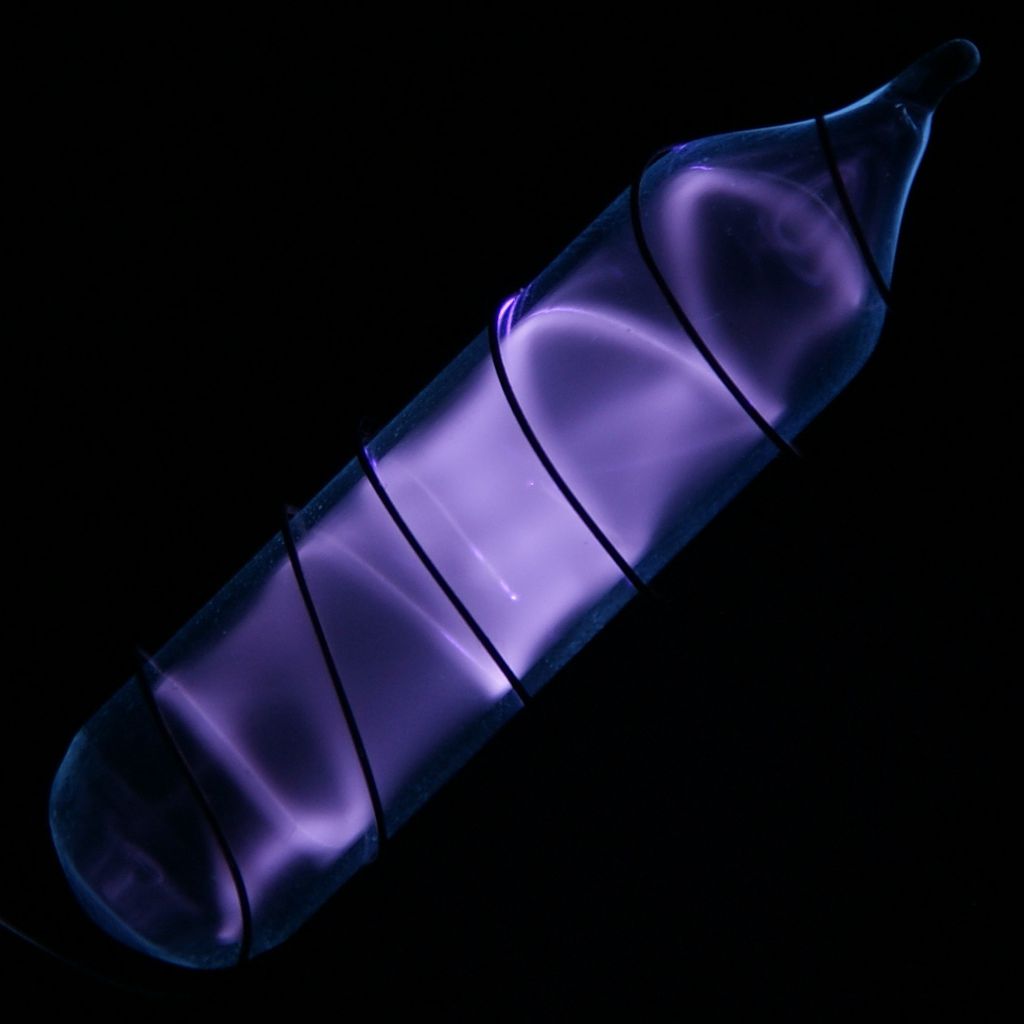 Frasco contendo o gás hidrogênio envolvido por um fio com corrente elétrica, o que provoca a exitação do gás e seu brilho (Imagem: Reprodução/Wikimedia Common/Jurii)
