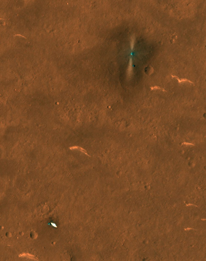 A imagem mostra o rover, o ponto em destaque no canto superior direito, e seu módulo de pouso. Na parte inferior esquerda da imagem, estão o paraquedas e o escudo traseiro (Imagem: Reprodução/NASA/JPL/UArizona)