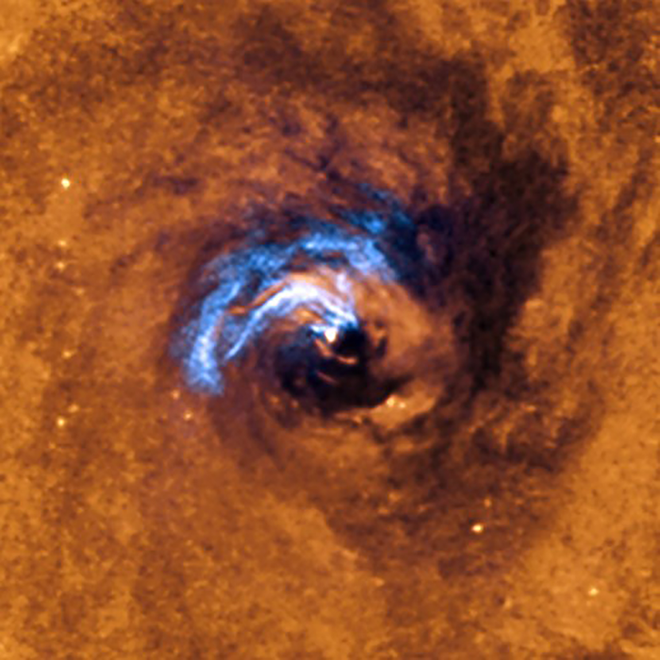 A imagem mostra o processo de alimentação de um buraco negro no centro da galáxia NGC 1566, e como os filamentos de poeira são aprisionados e giram em espiral até serem engolidos (Imagem: Reprodução/ESO)