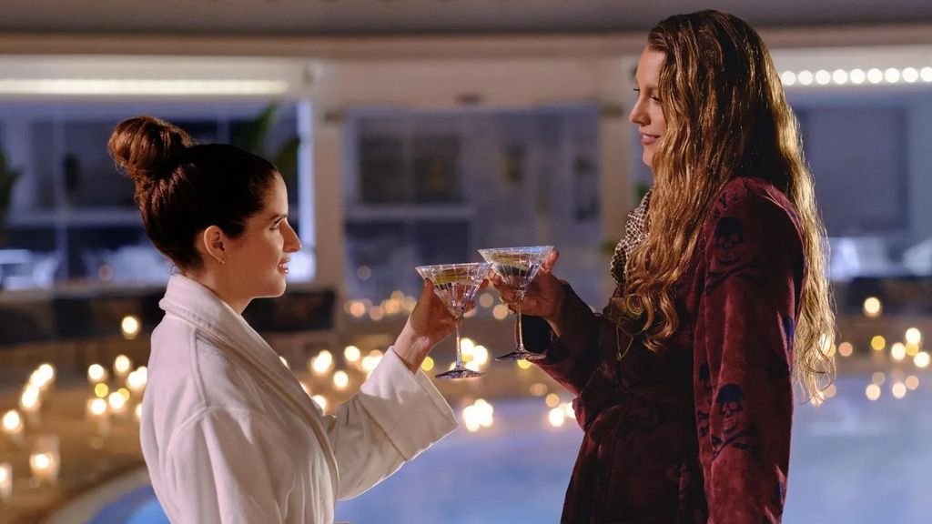 Duas mulheres brindando na frente de uma piscina