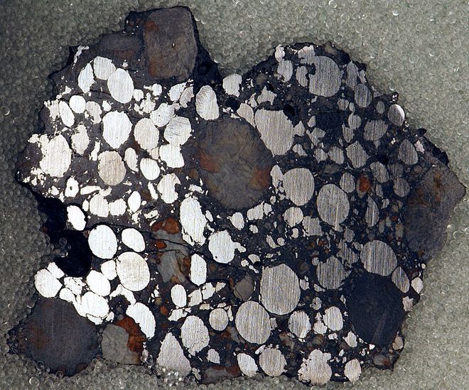 Exemplo de côndrulos, pequenas esferas metálicas no interior da rocha (Foto: Jon Taylor/CC2.0)