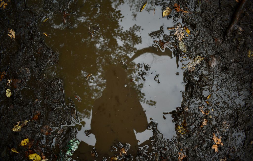 Reflexo de mulher em poça d'água