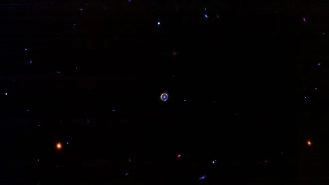 A galáxia lentificada, isto é, ampliada, aparece como um círculo vermelho neste anel de Einstein (Imagem: Reprodução/Spaceguy44/Reddit)